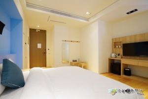 馬公市的住宿－宸楓民宿，卧室配有一张白色大床和一台平面电视。