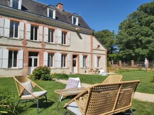 un groupe de chaises et une table devant une maison dans l'établissement Château de la Malmaison, à Champillon