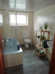 La salle de bains est pourvue d'une baignoire, de toilettes et d'un lavabo. dans l'établissement Poppenga - Feha Wallperle, à Emden