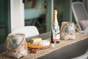 stolik z butelką szampana i sera w obiekcie Seascape On Shingley Whitsundays w mieście Airlie Beach