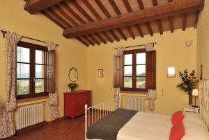 a bedroom with a bed and two windows at Agriturismo Scaforno Vacanze in Castelnuovo della Misericordia