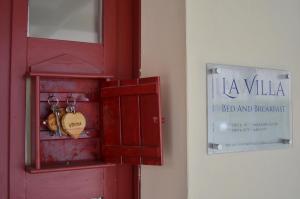 een rode deur met een bord met logies en ontbijt bij La Villa di Montagnana in Montagnana