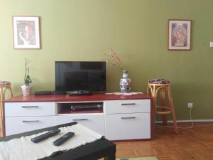 una sala de estar con un centro de entretenimiento blanco con TV en Apartment Stan Zadar en Zadar