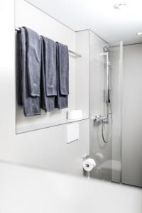 uma casa de banho com um chuveiro e toalhas azuis em Revier Mountain Lodge Adelboden em Adelboden
