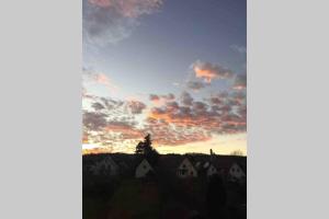 a sunset over a village with houses and a sky at Helle 2-Zimmerwohnung am Stadtrand in Hildesheim