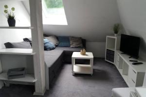 una pequeña sala de estar con sofá y cama en Helle 2-Zimmerwohnung am Stadtrand, en Hildesheim