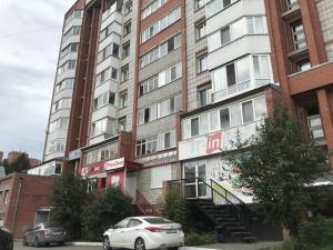 an apartment building with cars parked in front of it at ОК! Никитина, 20 №2 in Tomsk