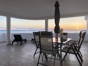 een eettafel en stoelen met uitzicht op de oceaan bij Villa Magia sul Mare in Petrcane