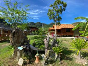 une maison avec un jardin et des arbres devant elle dans l'établissement Jing Jo Boutique Bungalow, à Sam Roi Yot