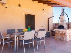 eine Terrasse mit einem Tisch, Stühlen und einem Kamin in der Unterkunft Na frare casa de campo in Ses Salines