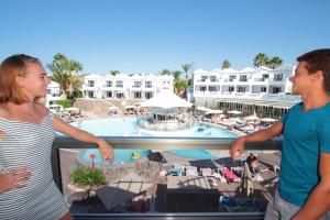 a man and a woman standing on a balcony at a resort at Turbo Club in Maspalomas