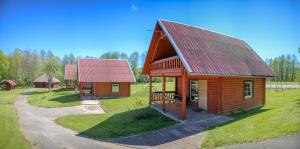 a small wooden cabin with a red roof at AB Imeda poilsiavietė in Ignalina