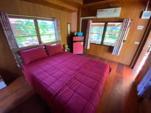 三百峰的住宿－Jing Jo Boutique Bungalow，一间卧室设有一张大紫色床和两个窗户