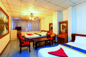 Habitación de hotel con 2 camas, mesa y sillas en Walking Street Encore Hotel en Pattaya South