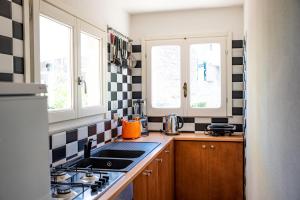 a kitchen with black and white tiles on the wall at la Casa Amaranto in SantʼAntìoco