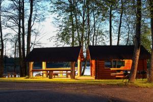 a log cabin with a black roof and a picnic table at AB Imeda poilsiavietė in Ignalina