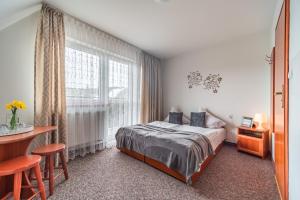 ein Schlafzimmer mit einem Bett und einem Tisch und einem Fenster in der Unterkunft Willa Tatra in Zakopane