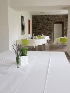 a dining room with white tables and green chairs at Schloß Wittgenstein in Bad Laasphe