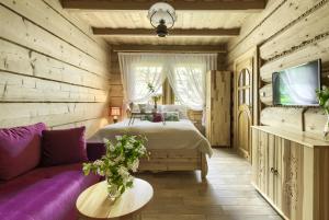 1 dormitorio con cama y sofá púrpura en Willa Hiacynta, en Zakopane