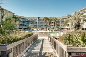 a boardwalk leading to a resort with a building at Breakers At Hilton Head in Hilton Head Island