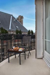 una bandeja de comida en una mesa en un balcón en Hotel La Manufacture, en París