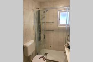 Un baño con ducha con puerta de cristal. en Apartmani Kvaternik - Stan Bol, en Bol 22 fotos más