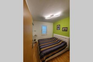 1 dormitorio con paredes verdes y 1 cama en Apartmani Kvaternik - Stan Bol, en Bol