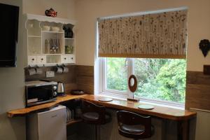 a kitchen with a window and a counter with chairs at Haydn House in Glastonbury