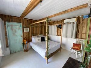 ein Schlafzimmer mit einem Himmelbett und einem Stuhl in der Unterkunft Memo's Beach in Nilaveli