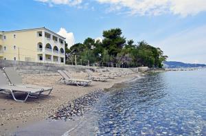 un gruppo di sedie su una spiaggia accanto all'acqua di Maria Mare Apart-hotel ad Argásion