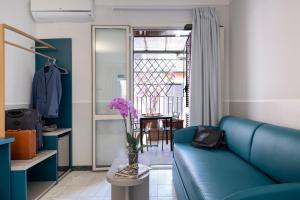 a living room with a blue couch and a vase of flowers at Hotel Grifo in Rome