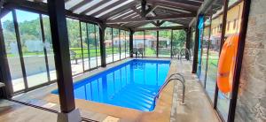 a swimming pool inside of a building with windows at Apartamentos El Castañeu in Corao
