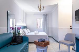 a bedroom with a white bed and a blue couch at Hotel Grifo in Rome