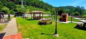 a park with picnic tables and a gazebo at Apartamentos El Castañeu in Corao