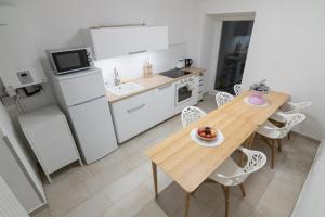 cocina con mesa de madera y electrodomésticos blancos en Yeshello Belvedere Apartment, en Viena