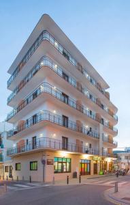een appartementencomplex met een witte gevel bij Hostal Alicante in San Antonio
