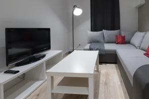 uma sala de estar com um sofá e uma televisão de ecrã plano em Yeshello Belvedere Apartment em Viena