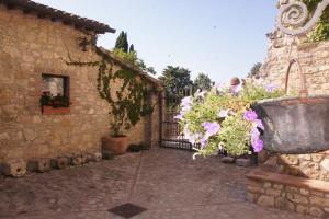 a stone building with a pot of flowers next to a building at Alloggio Castello di Loreto in Todi