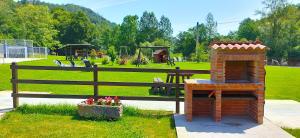 a playground with a brick fireplace in a park at Apartamentos El Castañeu in Corao