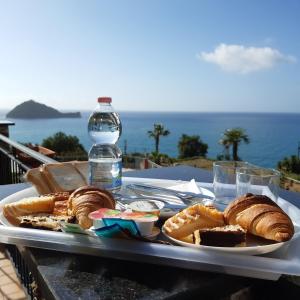 a tray of bread and pastries and a bottle of water at Verde Mare in Alassio