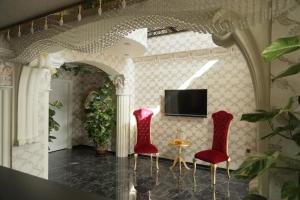 ArsuzにあるElada Luxury Otelのリビングルーム(赤い椅子2脚、テレビ付)