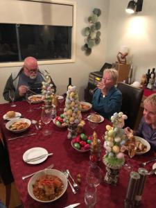 a group of three men sitting at a table with food at Riverview House Younghusband in Younghusband