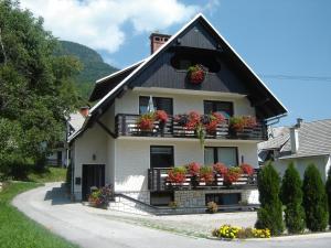 uma casa com caixas de flores nas varandas em Apartments & Rooms Stare em Bohinj