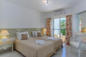 two beds in a room with a window at FLH Balaia Village Apartment with Pool I in Olhos de Água