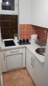 a kitchen with white cabinets and a sink at Liberty in Belgrade