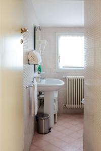 un bagno bianco con lavandino e finestra di Villa Meli Lupi - Residenze Temporanee a Parma