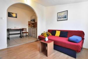 Una sala de estar con un sofá rojo y una mesa. en Villa Senjkovic - Apartments with Balcony and Sea View, en Bol