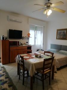ein Wohnzimmer mit einem Tisch mit Stühlen und einem TV in der Unterkunft Casa Francesca in Mailand
