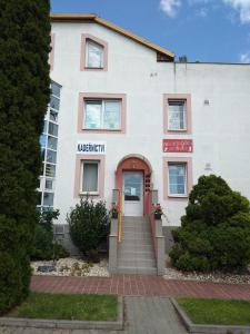 un edificio blanco con una puerta roja en Hotel Gregor, en Modřice