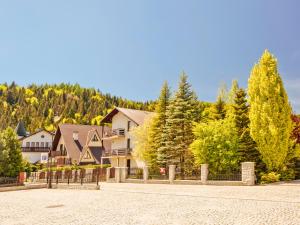 a resort with a fence and trees in the background at Pensjonat Klimek in Muszyna